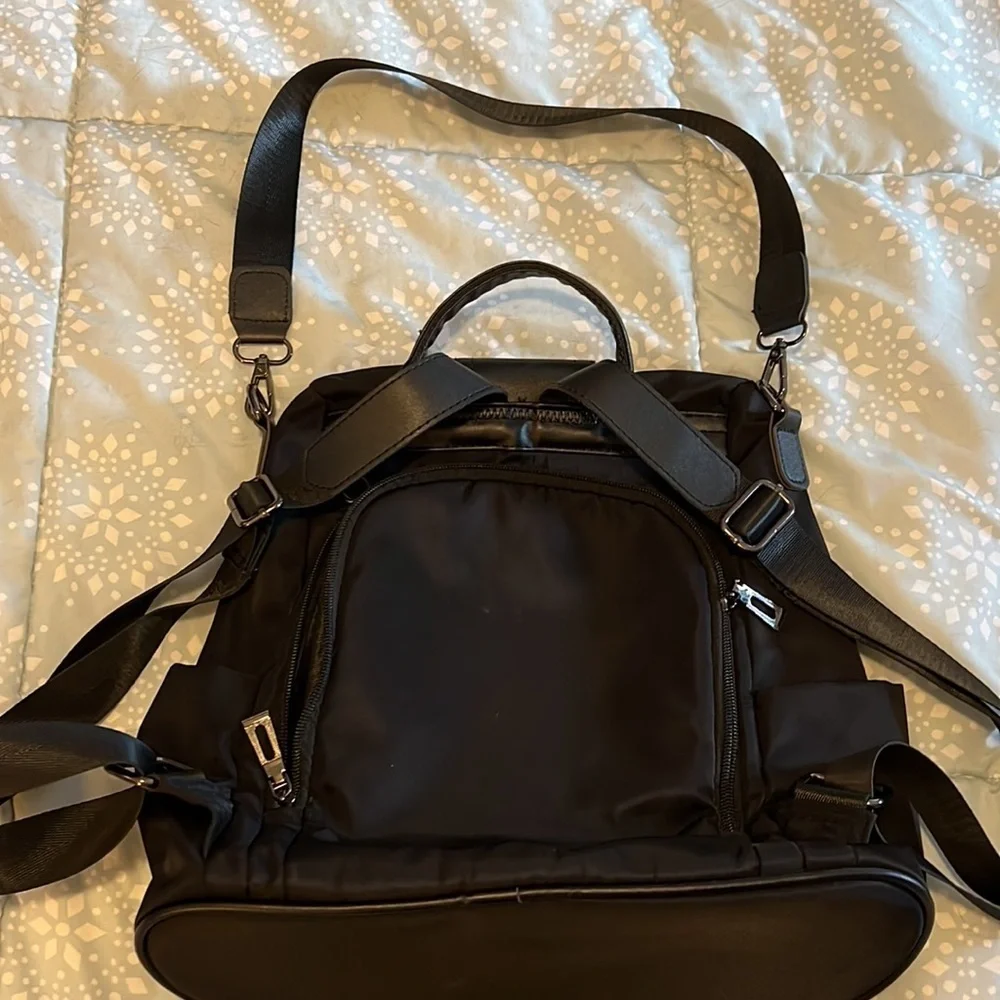 Black backpack, with strap and handle.